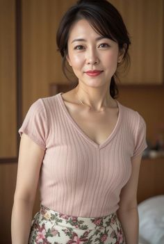 Woman in a pink t-shirt and floral skirt indoors