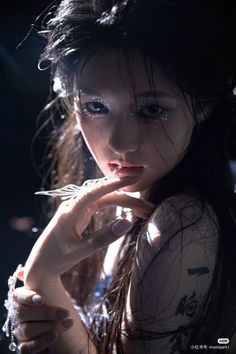 Woman with glitter makeup and long hair in dramatic lighting