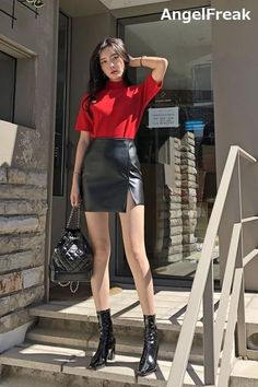 Woman in a red top and black leather skirt standing on outdoor steps