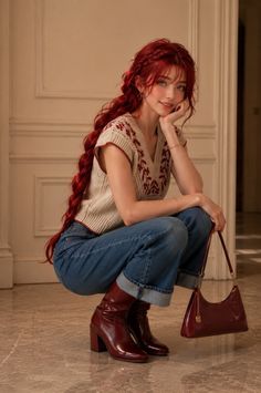 Woman with long red braided hair, wearing a vest, jeans, and red boots, holding a handbag