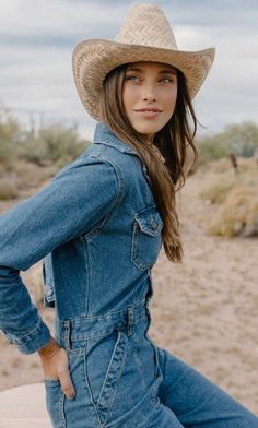 Woman in a denim jumpsuit and cowboy hat in a desert landscape