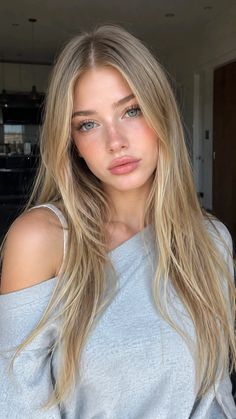 Blonde woman with blue eyes and freckles wearing an off-shoulder top