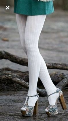 Person wearing white ribbed tights and floral platform heels on wet ground