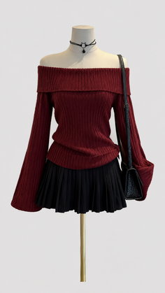 Mannequin wearing a red off-shoulder top, black pleated skirt, and choker
