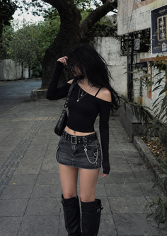Woman with long black hair in a crop top and denim mini skirt on a street