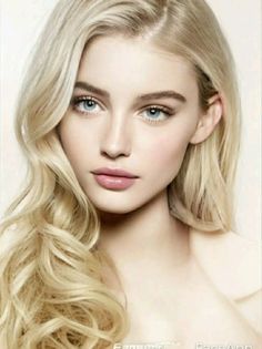 Woman with blonde wavy hair and blue eyes in a soft lighting portrait