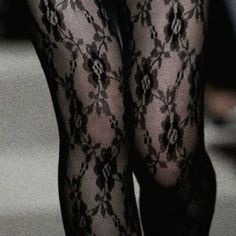 Close up of legs wearing black lace stockings with a floral pattern