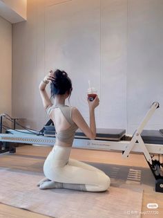 Woman in a yoga outfit with a bun hairstyle in a pilates studio