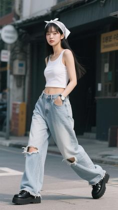 Woman in a white tank top and ripped jeans walking on a street
