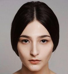 Woman with dark hair and natural makeup in a studio portrait