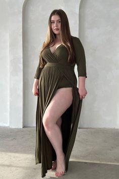 Woman in an olive green dress with a high slit and deep V-neck