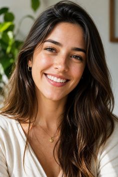 Woman with long brown hair and freckles smiling at the camera
