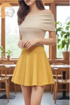 Woman in an off-shoulder top and yellow skirt indoors