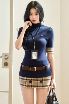 Woman with long black hair wearing a turtleneck top and plaid skirt indoors