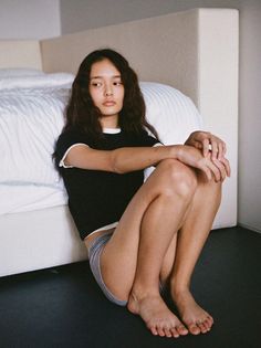 Woman with long hair sitting on the floor in a bedroom