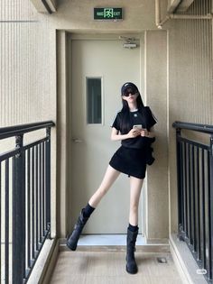 Woman in a black t-shirt and mini skirt posing indoors