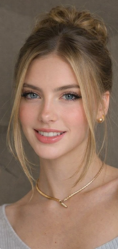Woman with blonde hair in an updo, wearing gold jewelry and smiling