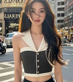 Woman with long hair wearing a black and white top on a city street