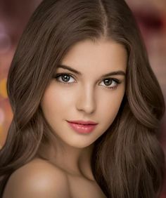 Woman with long brown hair and pink lips looking directly at the viewer