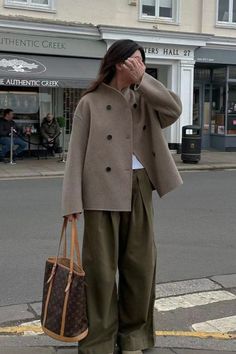 Woman in a double-breasted coat and wide-leg pants on a street