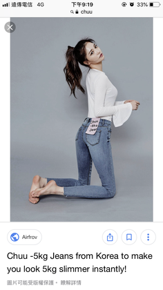 Woman in skinny jeans and a white long-sleeve shirt kneeling in a studio