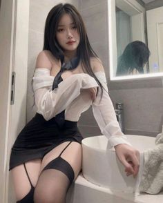 Woman in an off-shoulder shirt and mini skirt with stockings in a bathroom