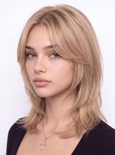 Woman with blonde hair and freckles wearing a cross necklace