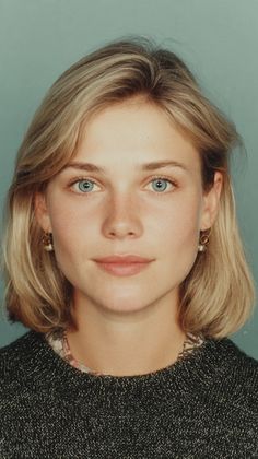 Woman with blonde hair and blue eyes wearing a dark sweater