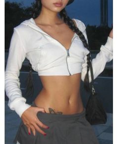 Woman in a white crop top with long braids and a butterfly tattoo