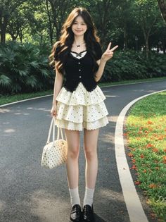 Woman in a black top and polka dot ruffle skirt posing outdoors