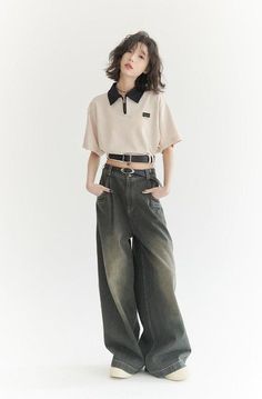 Woman with short hair wearing a polo shirt and wide leg jeans