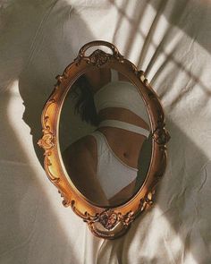 Reflection of a person in white underwear in an ornate mirror
