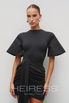 Woman in a black ruched dress with an updo and silver earrings