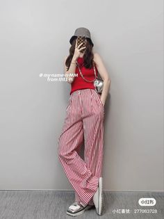 Person in a red tank top and striped pants taking a mirror selfie