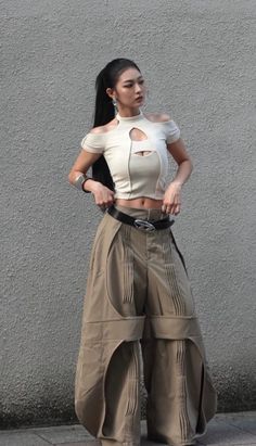 Woman in a cutout top and wide leg pants posing outdoors