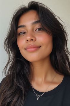 Woman with long dark hair and a necklace wearing a black shirt