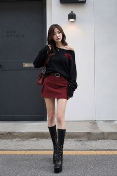 Woman in a black off-shoulder sweater and red mini skirt with knee-high boots