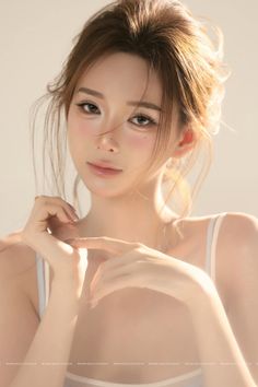 Woman with light brown hair in an updo, posing with soft lighting