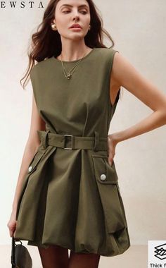 Woman in an olive green belted dress with gold jewelry