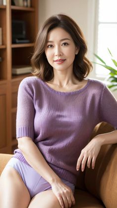 Woman with short hair wearing a sheer purple top and underwear indoors