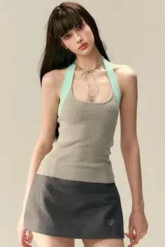 Woman with long dark hair wearing a halter top and mini skirt in a studio