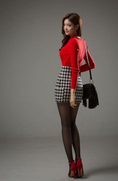 Woman in a red top and houndstooth skirt with black tights and red heels