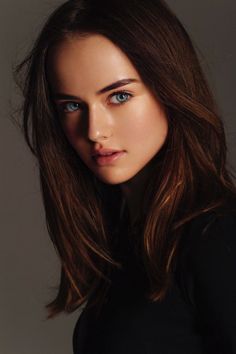 Woman with long dark hair and blue eyes in a soft-lit portrait