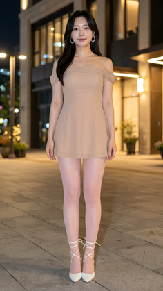 Woman in an off-shoulder dress and pink tights standing outdoors at night