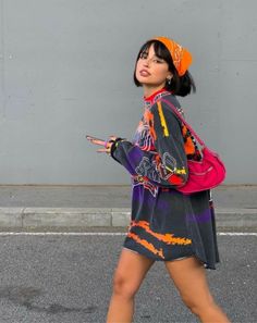 Woman in an oversized t-shirt and bandana walking on a street