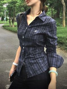 Person in a plaid shirt and jeans outdoors with a ponytail