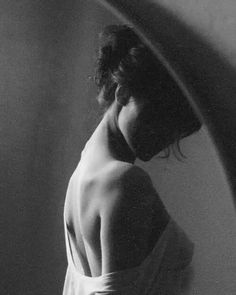 Woman with exposed back in a dark, dramatic black and white photograph