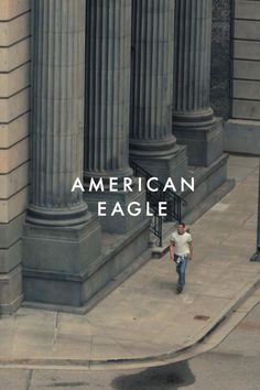 Man walking on a sidewalk next to large columns