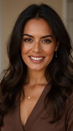 Woman with long wavy hair and brown eyes smiling at the camera
