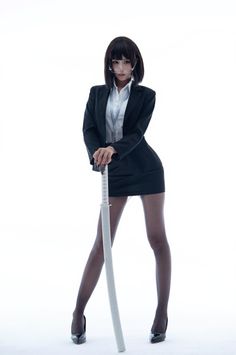 Woman in a business suit and pantyhose holding a katana on a white background